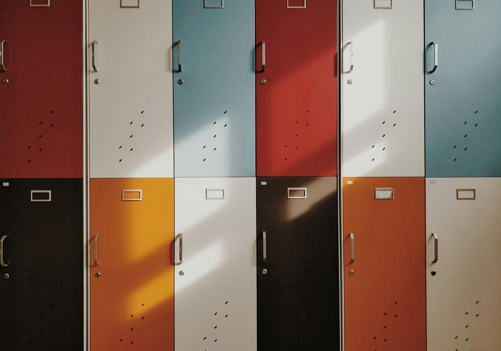 A wall of red, orange, blue and cream school lockers